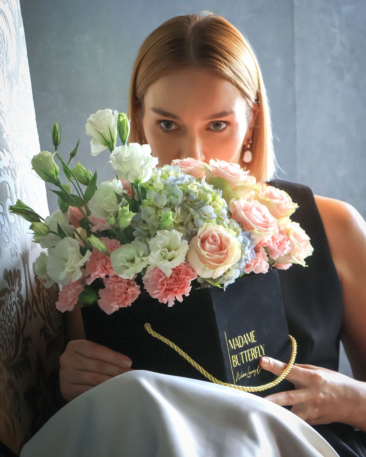 arreglo de rosas y hortensias que fusiona la ternura de las rosas rosadas con la frescura de mini hortensias, lisianthus y claveles, creando un universo floral de lujo y distinción.