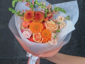 bouquet de rosas y dhalias que combina la calidez de las rosas peach, la exclusividad de las dragonarias y la majestuosidad de las dhalias.
