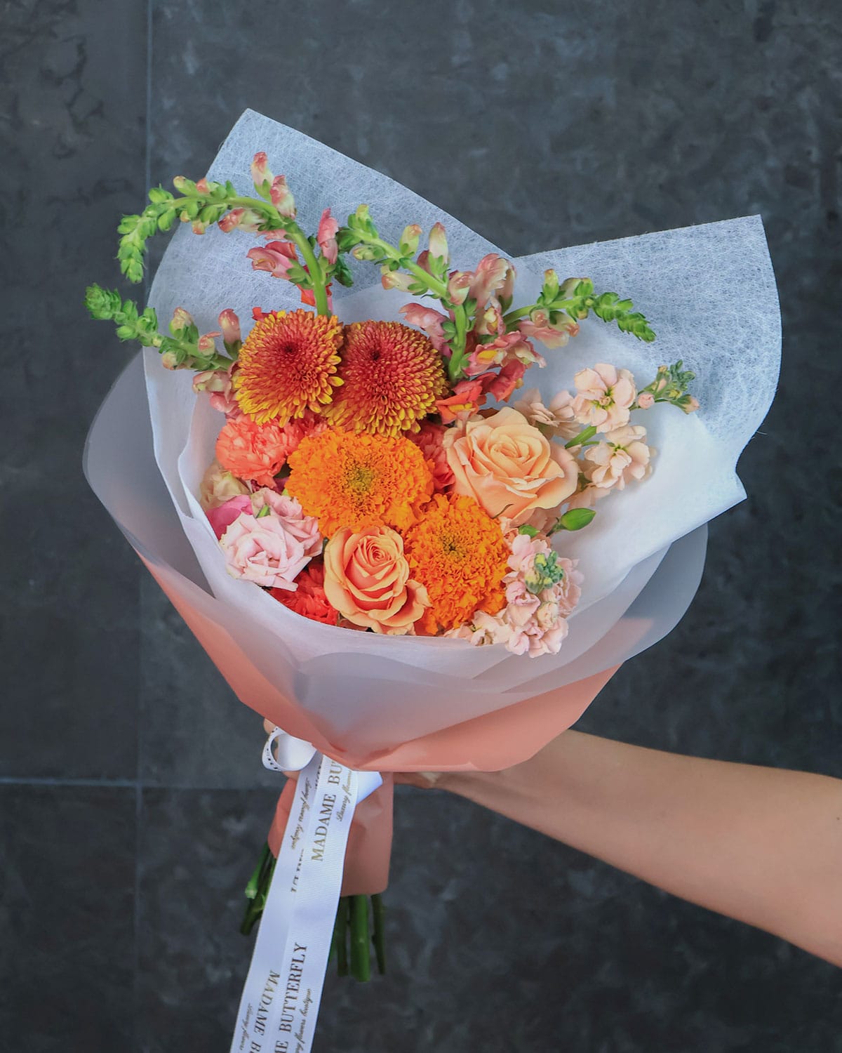 bouquet de rosas y dhalias que combina la calidez de las rosas peach, la exclusividad de las dragonarias y la majestuosidad de las dhalias.