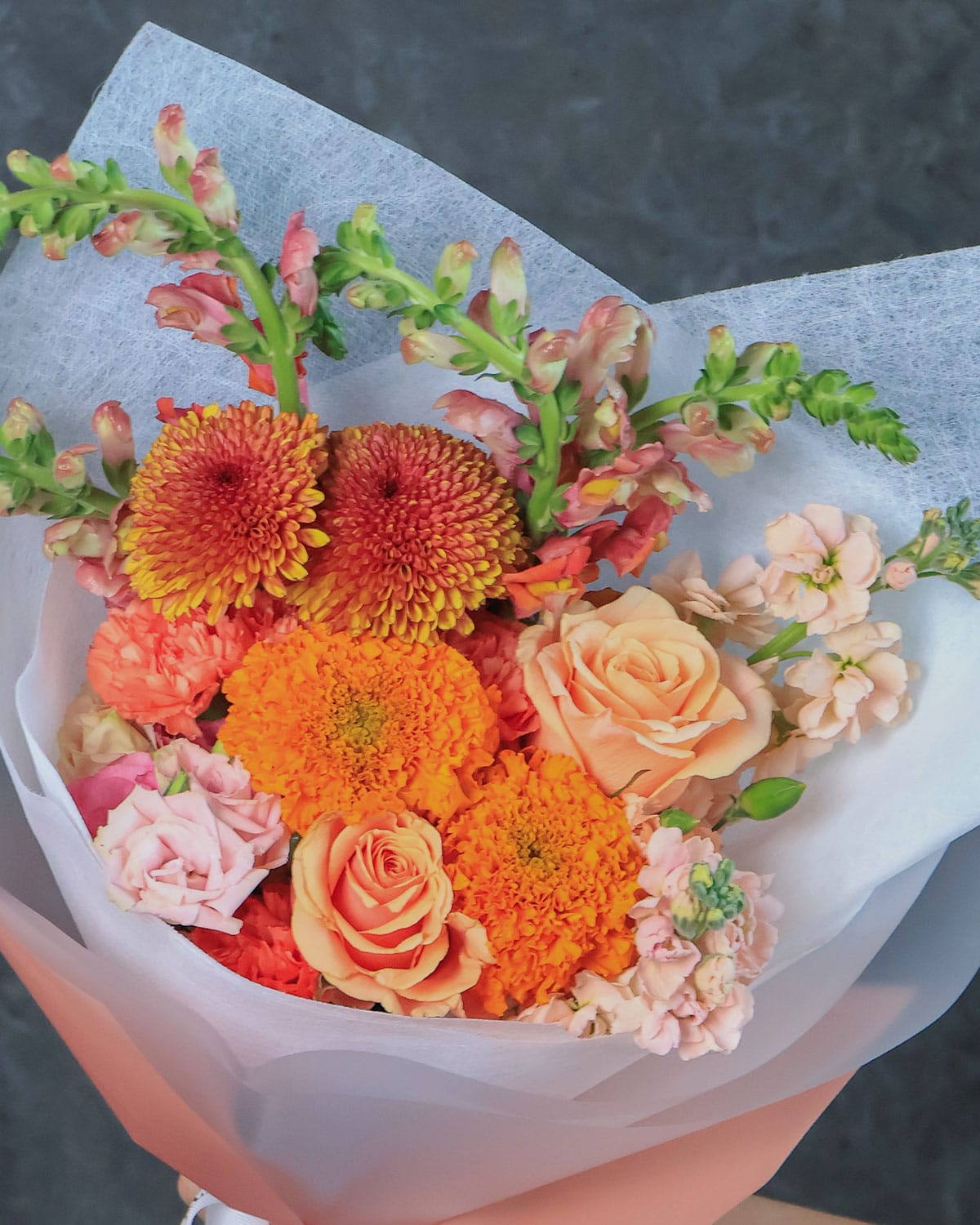bouquet de rosas y dhalias que combina la calidez de las rosas peach, la exclusividad de las dragonarias y la majestuosidad de las dhalias.